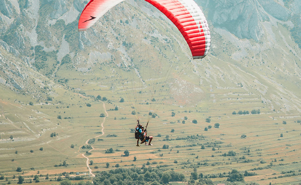 A guy that is flying above hills