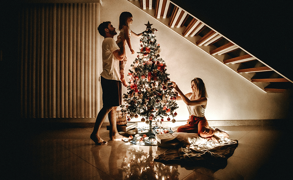 family decorating a Christmas tree with ornaments