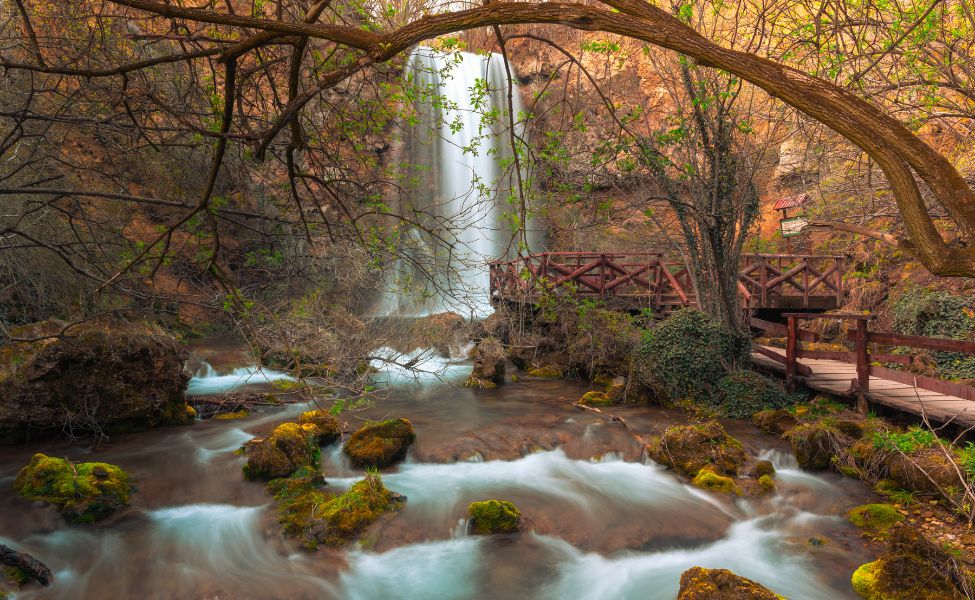 Nature around the waterfall and a deck leading to it 