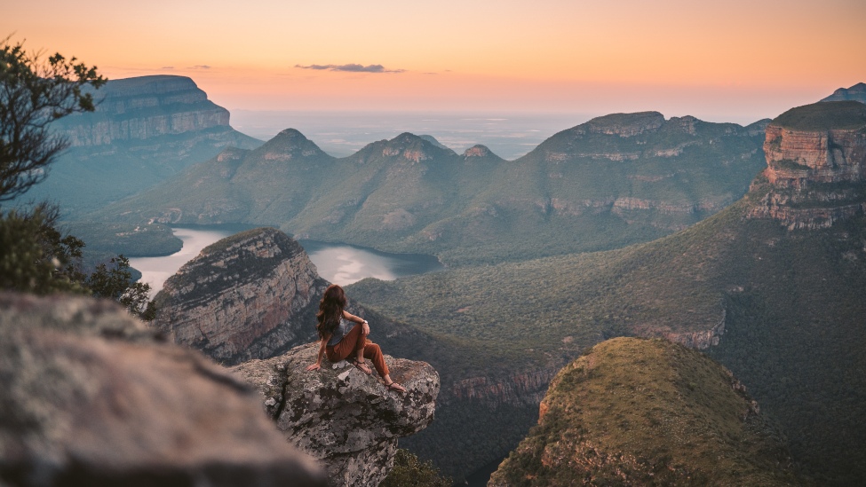 Woman sitting on a mountain top 