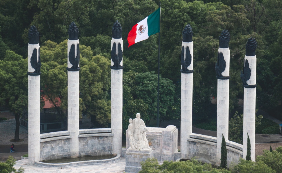 Statues and a Mexican flag in a park