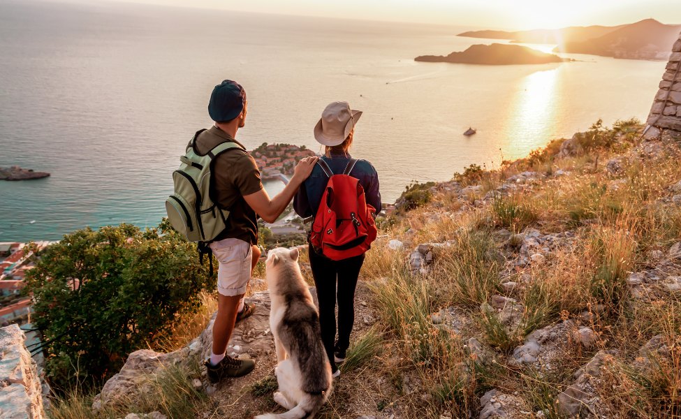 Tourists with a dog overlooking Sveti Stefan island 